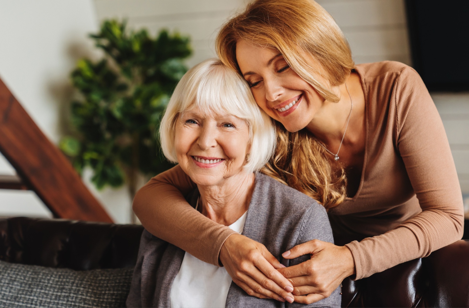 A young family member hugging their mother from behind and being happy together.