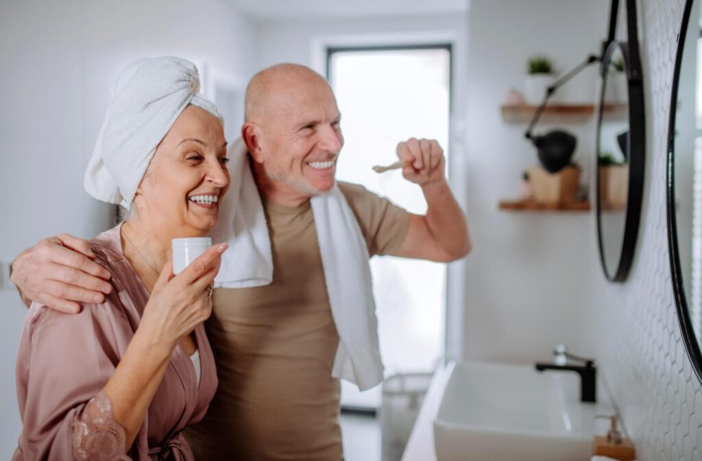 A senior couple gets ready for bed in their bathroom, brushing their teeth and using mouthwash to protect their oral health